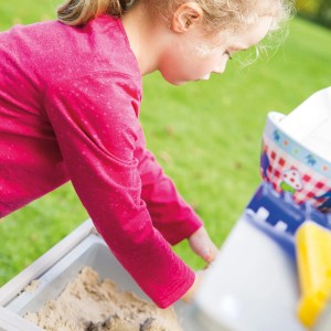Mädchen spielt mit Sand in grauer roba Outdoor Kinderküche mit Spielwannen.