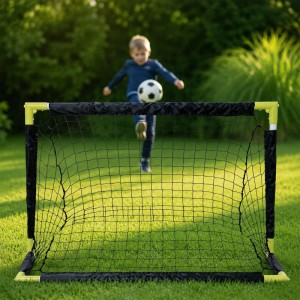 Schwarz-gelbes Fußballtor auf Rasen, Kind spielt Fußball. Faltbares PVC-Polyester Tor für Spiel & Spaß im Garten.