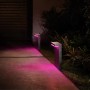 Philips Hue Nyro Sockelleuchte, schwarz, mit farbigem Licht im Garten.