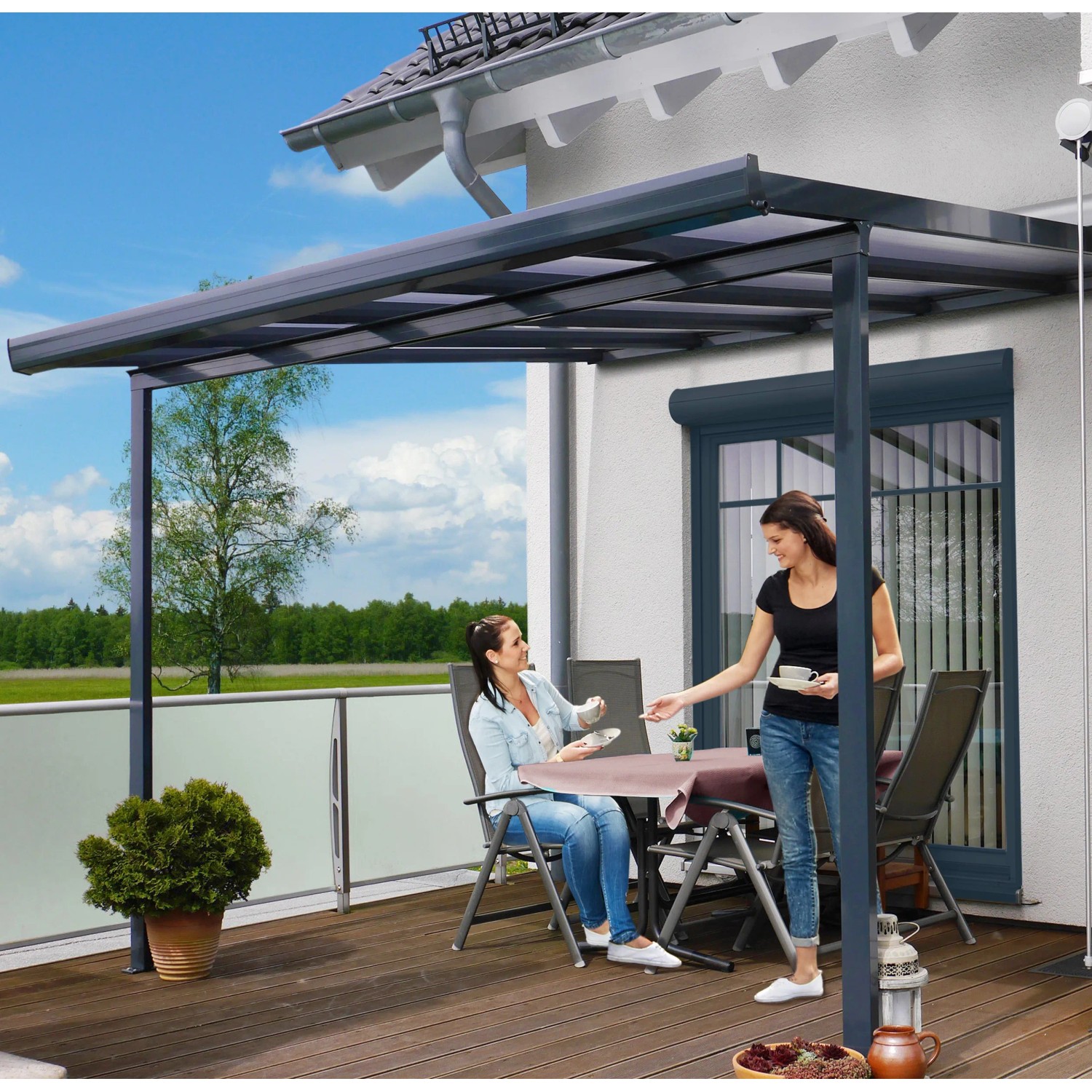 Anthrazit Terrassenüberdachung Bausatz (306x306cm) mit Polycarbonatplatten und zwei Frauen auf der Terrasse.