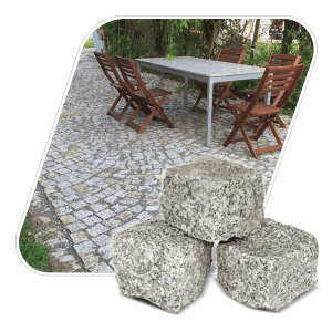 Galamio Granitpflastersteine 8/11 gespalten, Bigbag mit rustikalem Gartenweg und Sitzgruppe im Hintergrund.