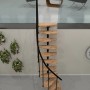 Minka Raumspartreppe Monte Carlo Buche-Schwarz, gewendelte Innentreppe mit Holzstufen und Metallgeländer.