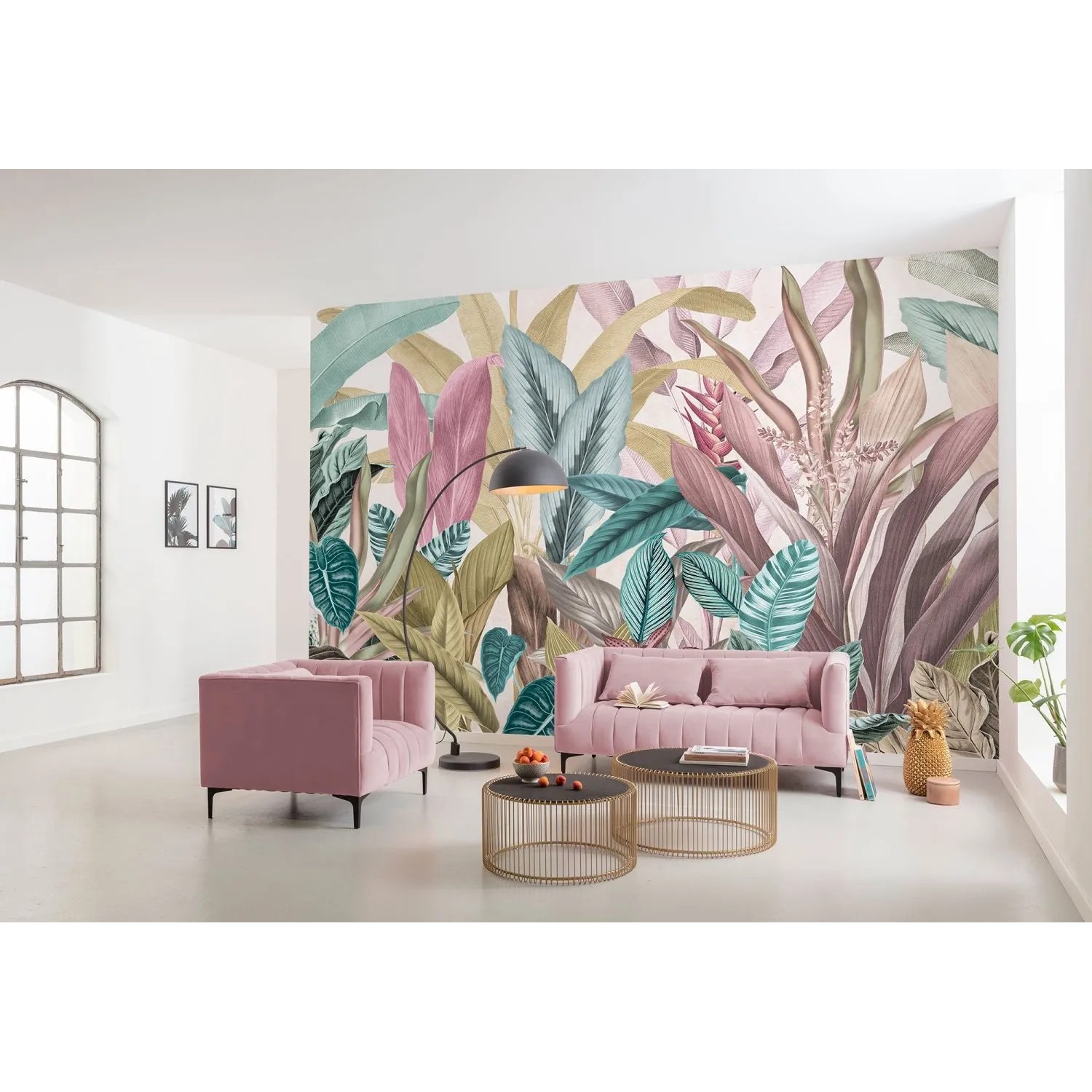 Komar Fototapete Mathilda Multicolor (350x250 cm) im Wohnraum mit rosa Sofa und tropischen Blättern.