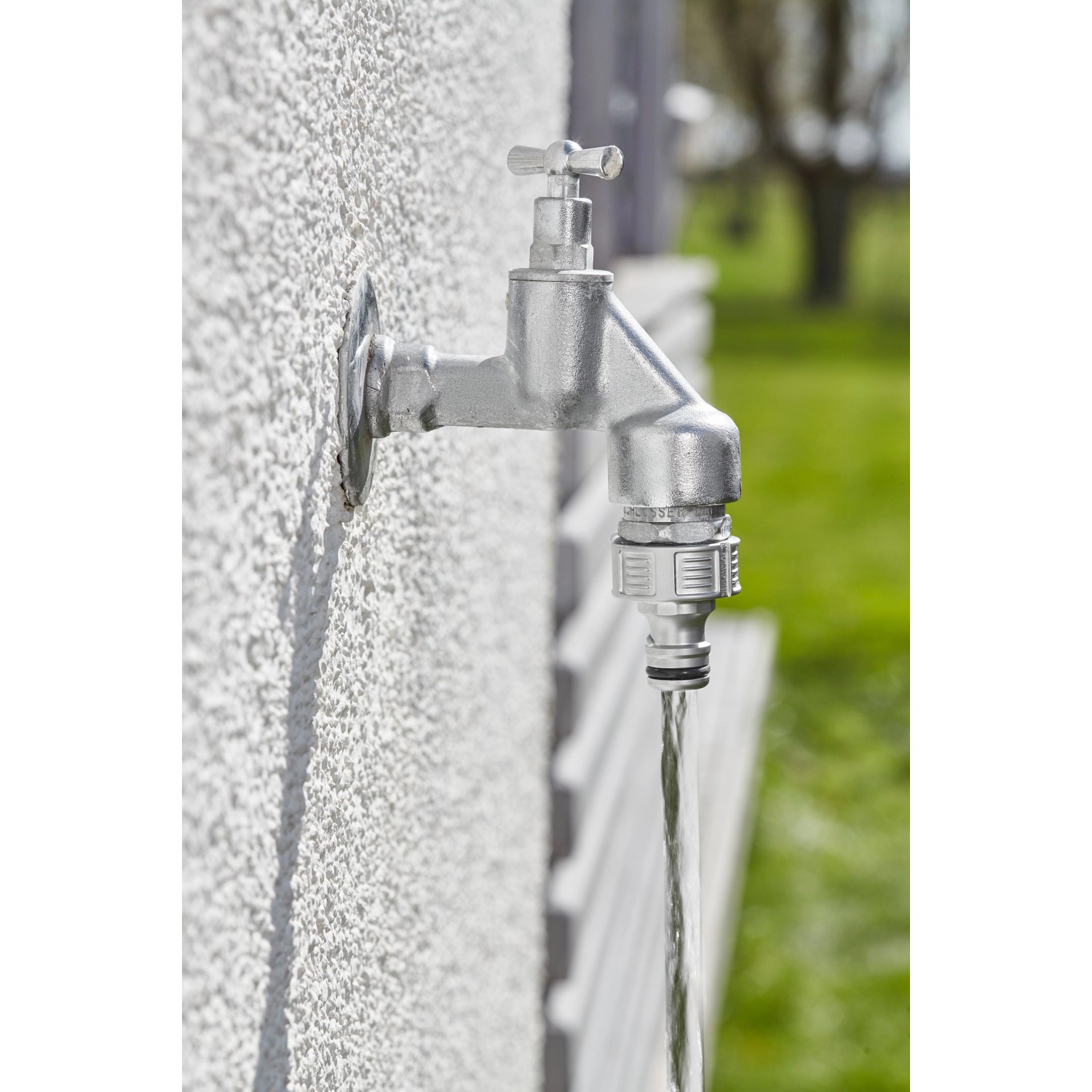 Gardena Premium Hahnverbinder (G 1'') am Wasserhahn mit laufendem Wasser.
