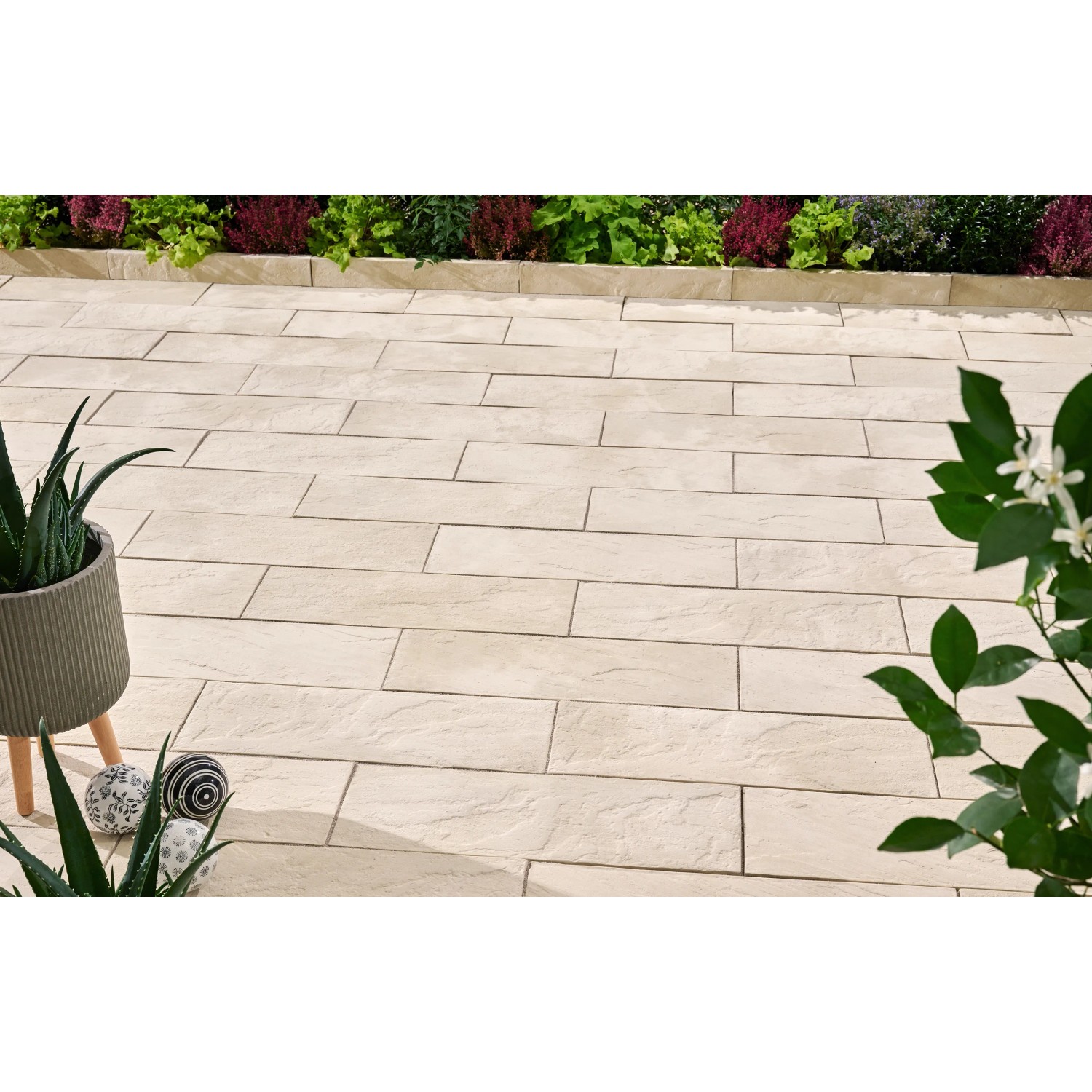 Verlegte Dielenplatten Nativa in Kalksteinoptik, 60x20x4 cm, als Trittsteine im Garten.
