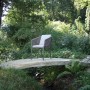 Anthrazitfarbener Acamp Manhattan Armsessel mit Kissen im Garten.