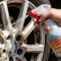Hand sprüht Ballistol Felgenreiniger auf verschmutzte Autofelge. Pumpspray 750 ml für effektive Reinigung.
