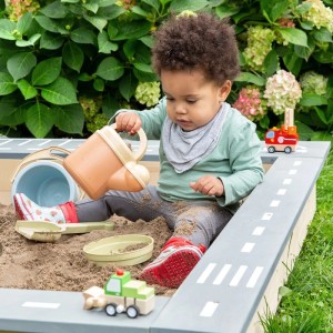 MUDDY BUDDY Sandkasten Highway Hero: Kind spielt im Sandkasten mit Spielstraße und Spielzeug.