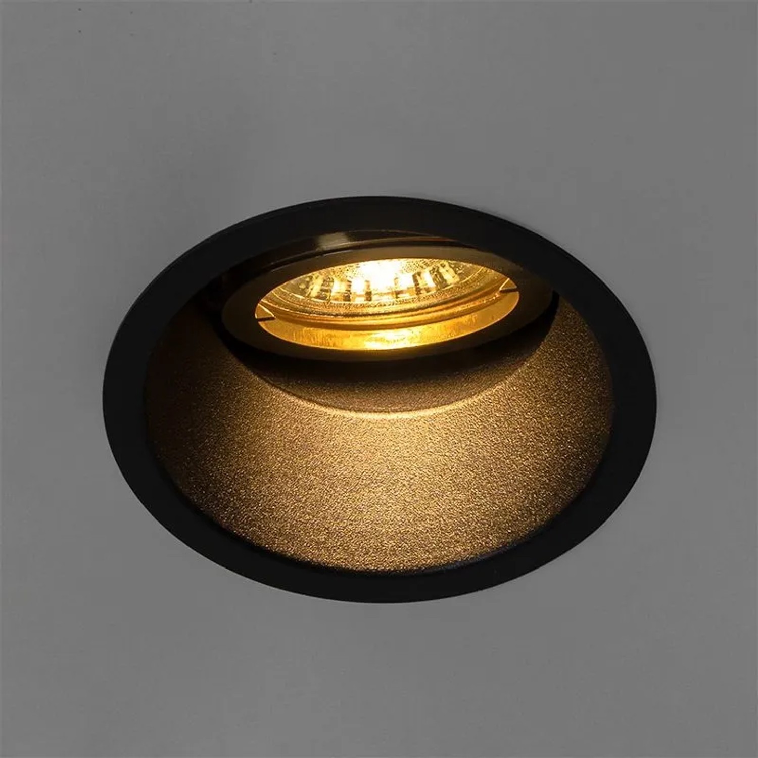 Schwarzer QAZQA Einbaustrahler mit goldenem, drehbarem Aluminium-Innenring.