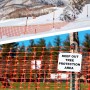 Oranger KARAT Absperrzaun Chester als Begrenzungszaun auf Schnee und Wiese.