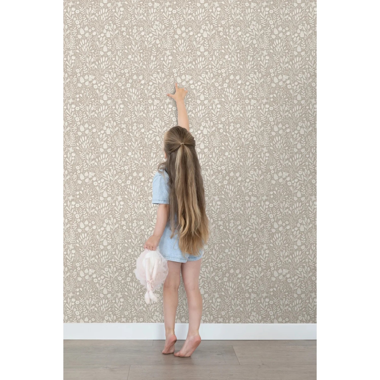 ESTAhome Vliestapete Hellbeige mit Blumenmuster, ein Kind berührt die Wand. Dekorative Tapete für ein freundliches Kinderzimmer.