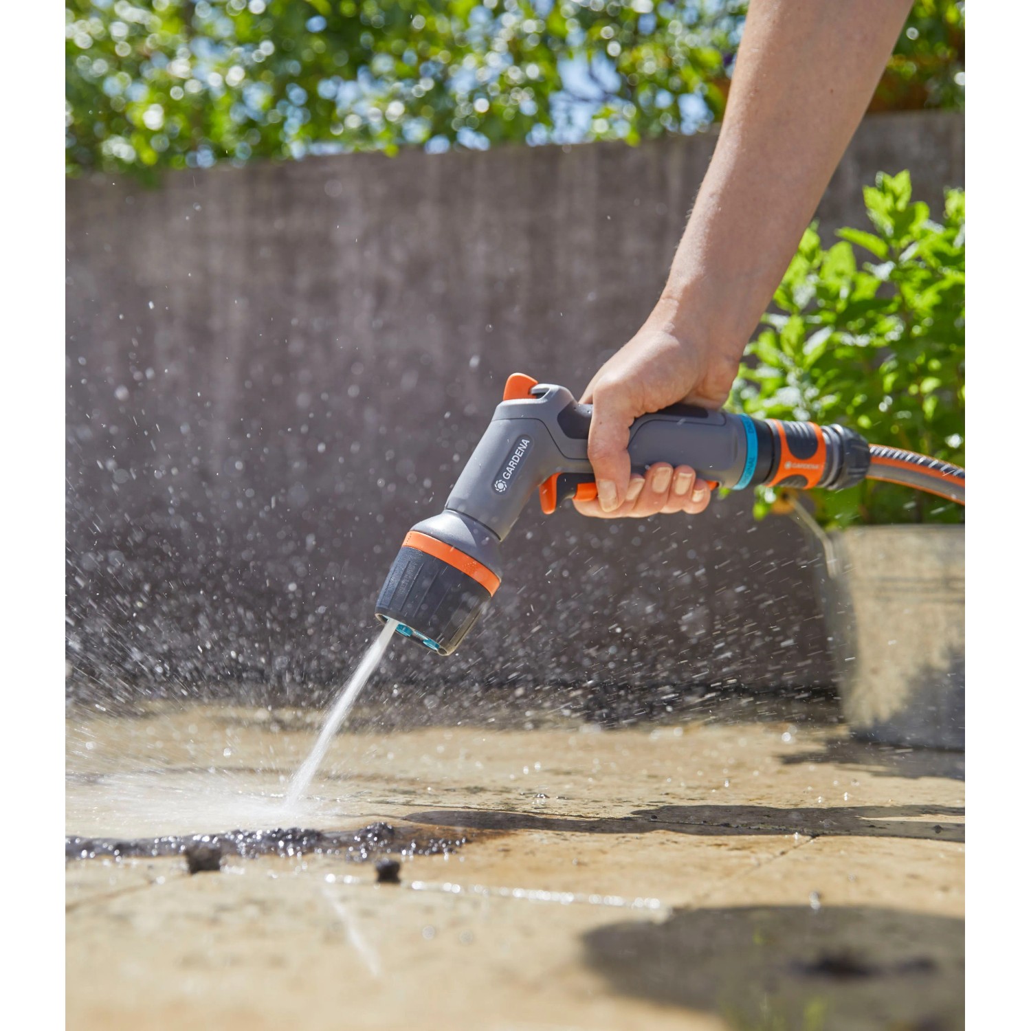 Gardena Comfort Reinigungsspritze ecoPulse™ in Aktion: Flächenreinigung mit Wasserstrahl.