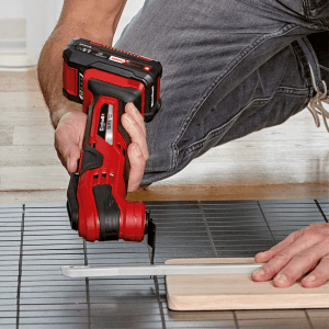 Einhell Multitool im Einsatz: Multifunktionswerkzeug mit Sägeblatt schneidet Holz, ideal für Renovierungsarbeiten.