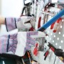Hände mit Arbeitshandschuhen Gr. 8 vor Werkzeugwand. Schutzhandschuhe für Handwerk und Garten.