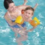 Kind mit Bestway Früchte-Schwimmflügeln im Pool, gehalten von einer Frau. Gelbe Schwimmhilfe mit Früchte-Motiv.