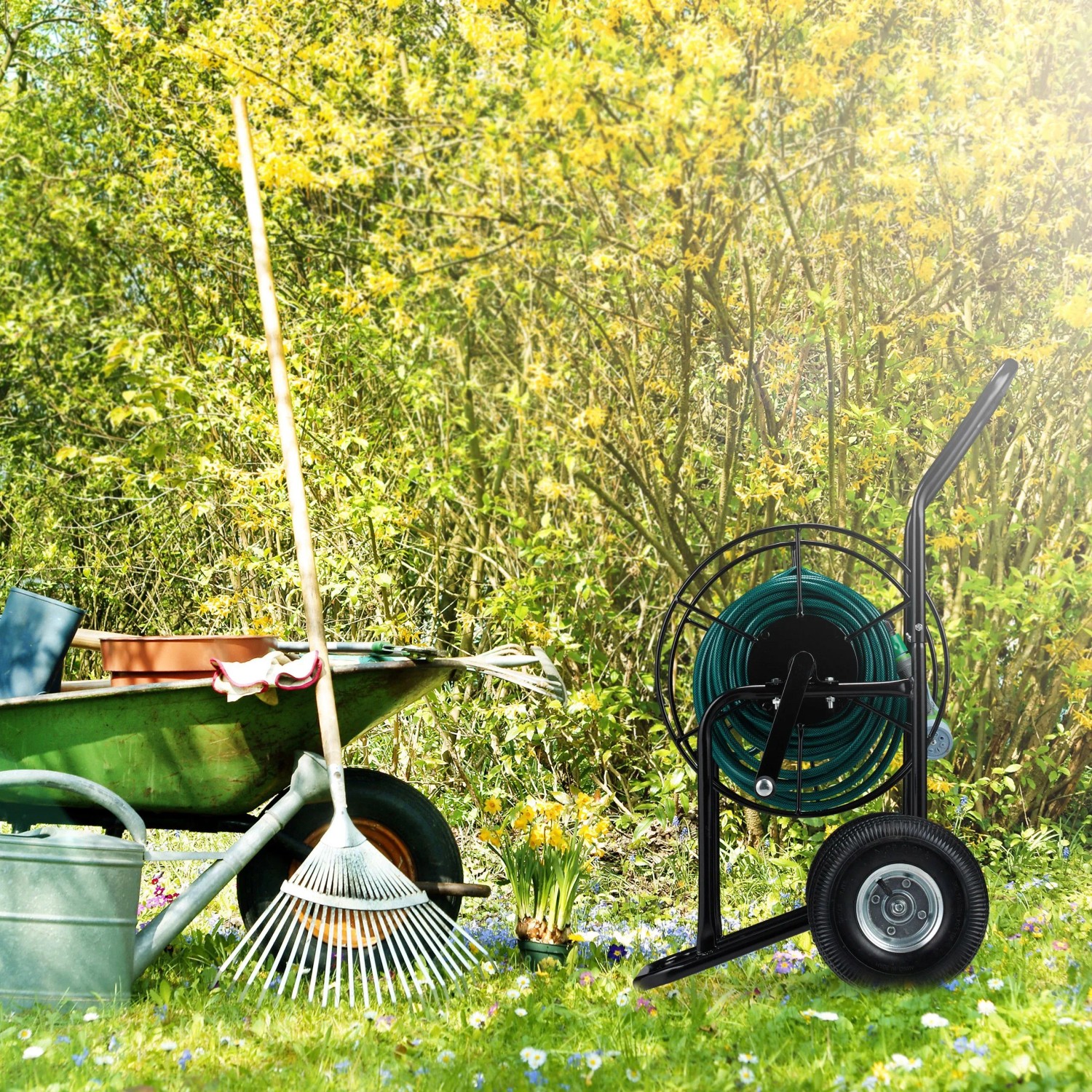 Schwarzer Relaxdays Schlauchwagen aus Metall mit grüner Schlauchtrommel und Rädern im Garten. Für Wasserschläuche.