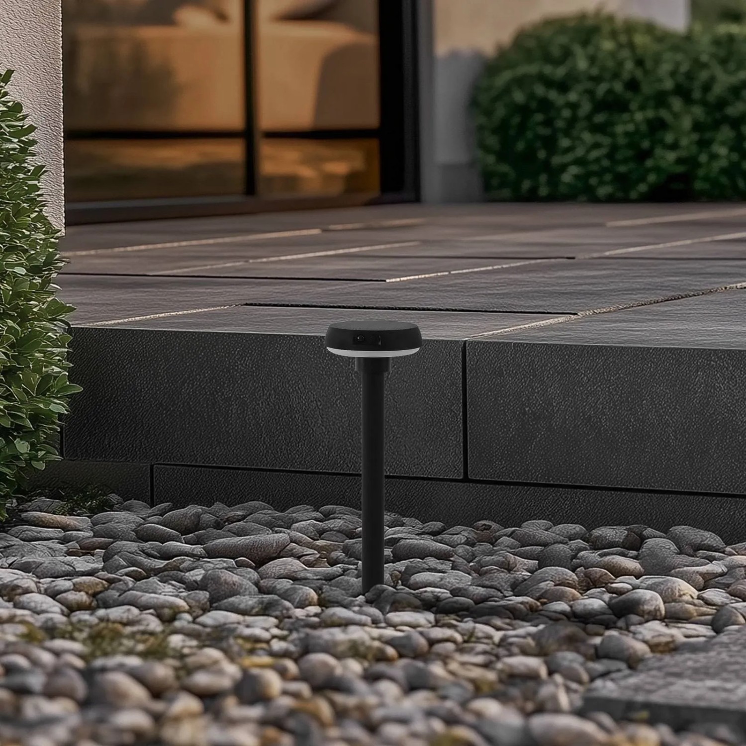 Schwarze Lindby LED Solarleuchte Brinca mit Bewegungsmelder im Garten.