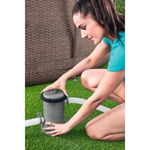 Frau installiert Bestway Flowclear Pool Filterpumpe (2.006 l/h) mit Schläuchen am Pool.
