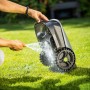 Reinigung des LUX-TOOLS Mähroboter Oryx 300 Vision mit Wasserschlauch auf Rasen.