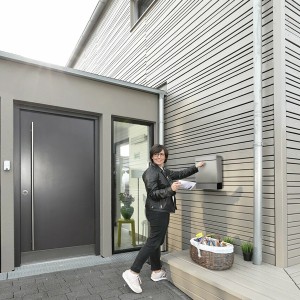 Frau wirft Post in Burg-Wächter Briefkasten Seattle Edelstahl mit Zeitungsbox.