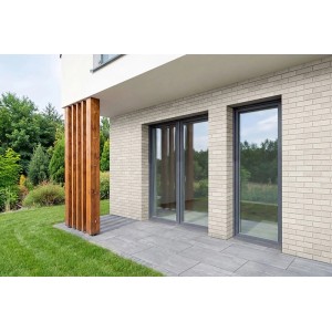 Helle Fassade mit Elabrick Verblender Bristol in Weiß, kombiniert mit grauer Terrasse und dunklen Fensterrahmen.