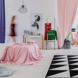 Schwarze Relaxdays Handtuchleiter aus Eisen, anlehnbar, mit Kleidung im Schlafzimmer.