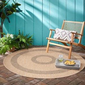 Runder, schwarzer Ayyildiz Outdoor-Teppich Comilla (80x80 cm) auf Terrasse mit Stuhl.