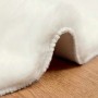 Flauschiger, cremefarbener vidaXL Kunstfell Hasen Teppich Olite aus Polyester, weich und rund, auf Holzboden.