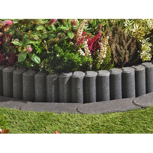 Anthrazitfarbene Rundpalisaden als Beeteinfassung im Garten.