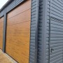Große Liderstal Fertiggarage 12x8m in Graphit mit drei Sektionaltoren in Goldene Eiche Holzoptik und Seitentür.