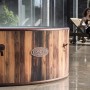 LAY-Z-SPA Helsinki AirJet Whirlpool in Holzoptik, rund, mit Frau auf Liege im Hintergrund.