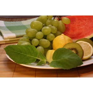 Frischer Fruchtsalat mit Salbei: Trauben, Zitrone, Kiwi und Wassermelone mit Salbei-Blättern.