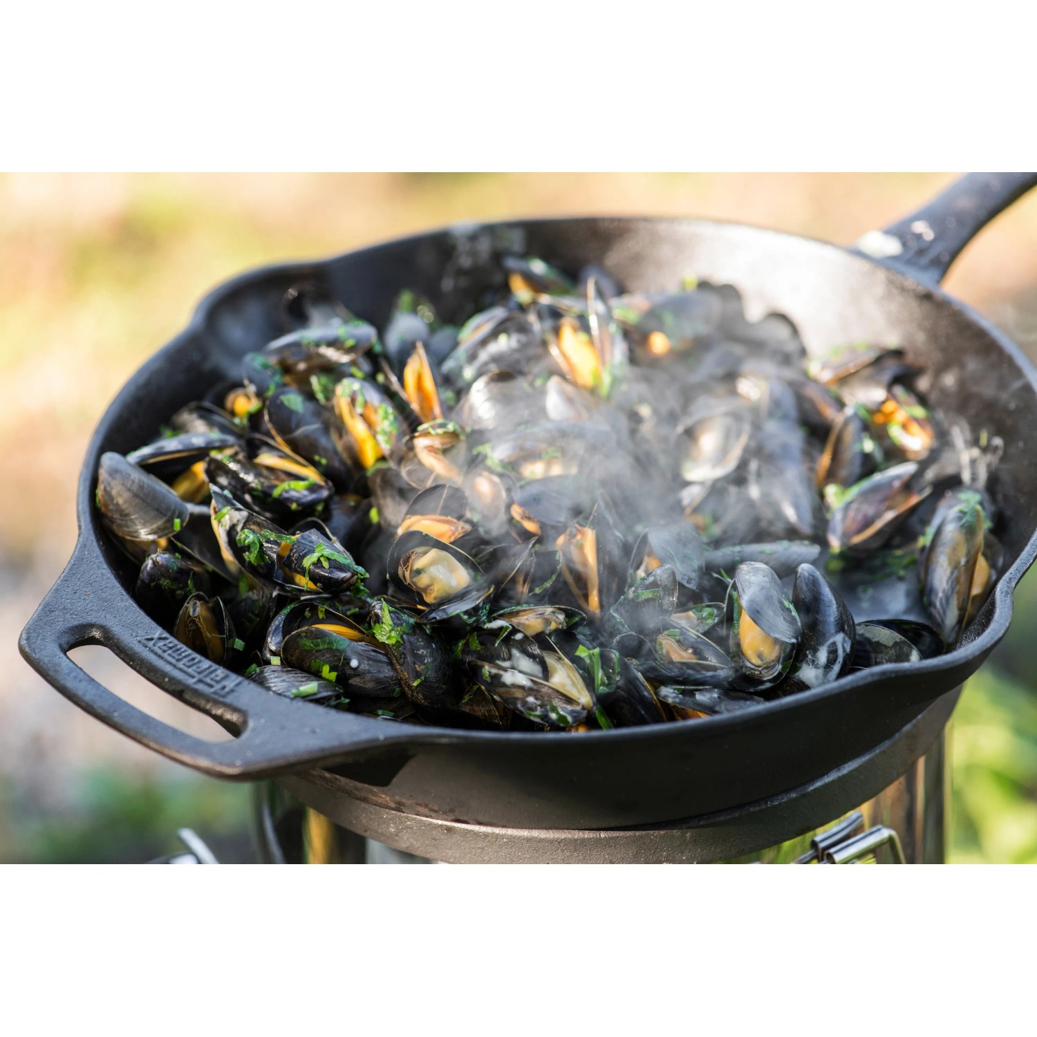 Petromax Feuerpfanne FP30-T: Gusseisenpfanne mit dampfenden Muscheln, ideal zum Grillen.