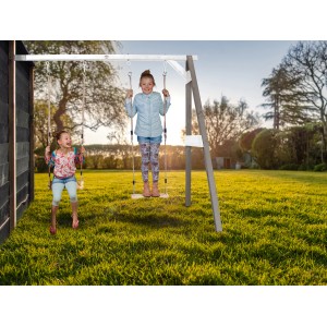 Axi Doppel-Anbauschaukel in Grau und Weiß mit zwei Kindern beim Schaukeln im Garten.