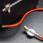 Detailaufnahme: Grillfürst G201E Gasgrill mit Gasschlauch und Druckminderer.