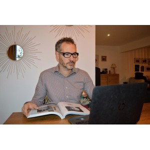 Mann mit Varionet Mehrzweck-Schutzbrille Tech 3in1 +1,0 beim Lesen und Arbeiten am Laptop.