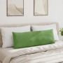 Langes, hellgrünes Cord Sofakissen auf einem beigen Bett mit weißen Kissen. Modernes Design für Wohn- & Schlafzimmer.