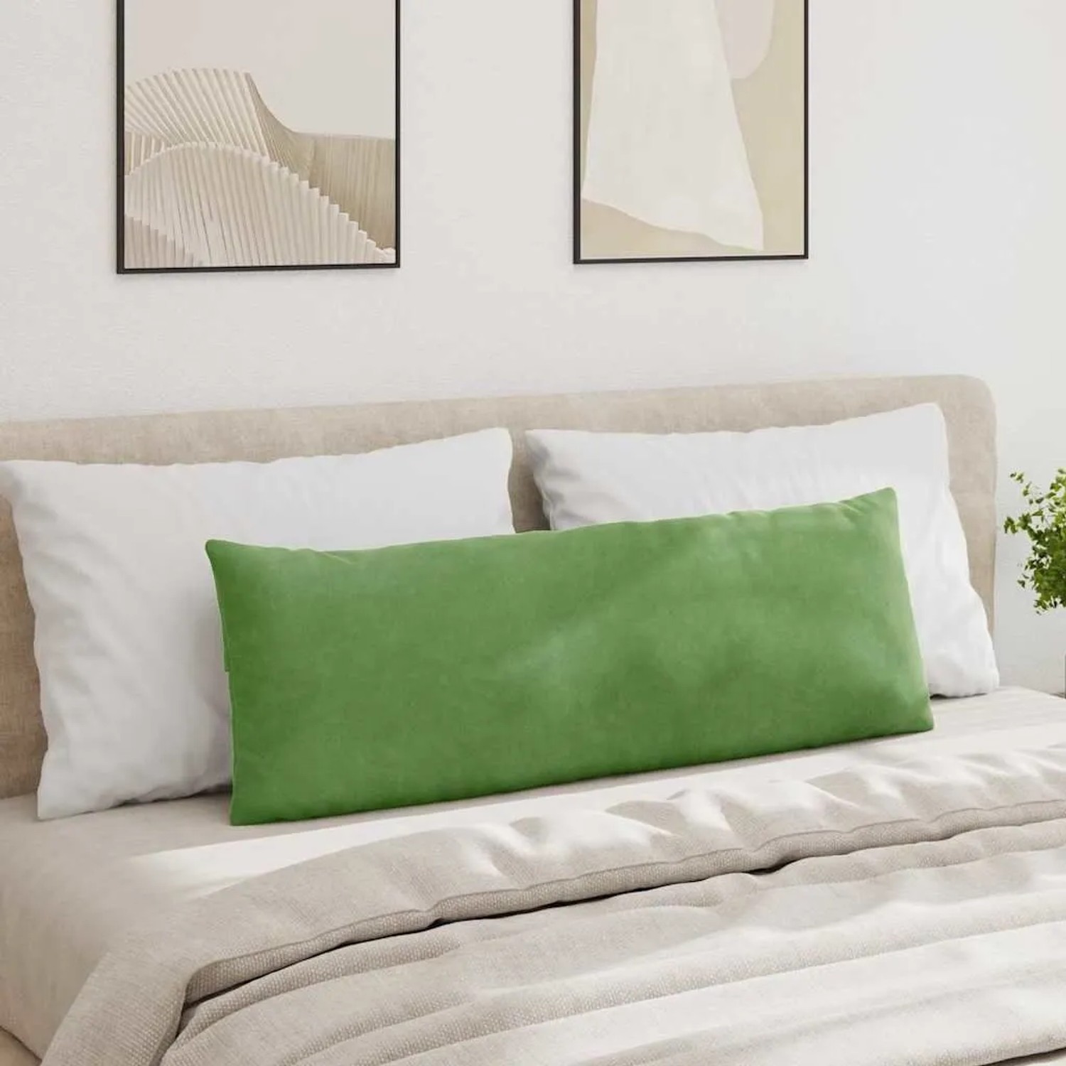Langes, hellgrünes Cord Sofakissen auf einem beigen Bett mit weißen Kissen. Modernes Design für Wohn- & Schlafzimmer.