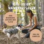 Frau spielt mit Hund mit blau-orangem Rudelkönig Hundeball (6,5 cm) aus Naturkautschuk im Wald.