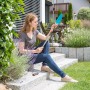 Frau nutzt Gardena combisystem Blumenkelle mit Stiel im Garten.