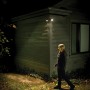 Mr. Beams LED-Außenwandleuchte mit Sensor beleuchtet Hauswand und Gehweg.