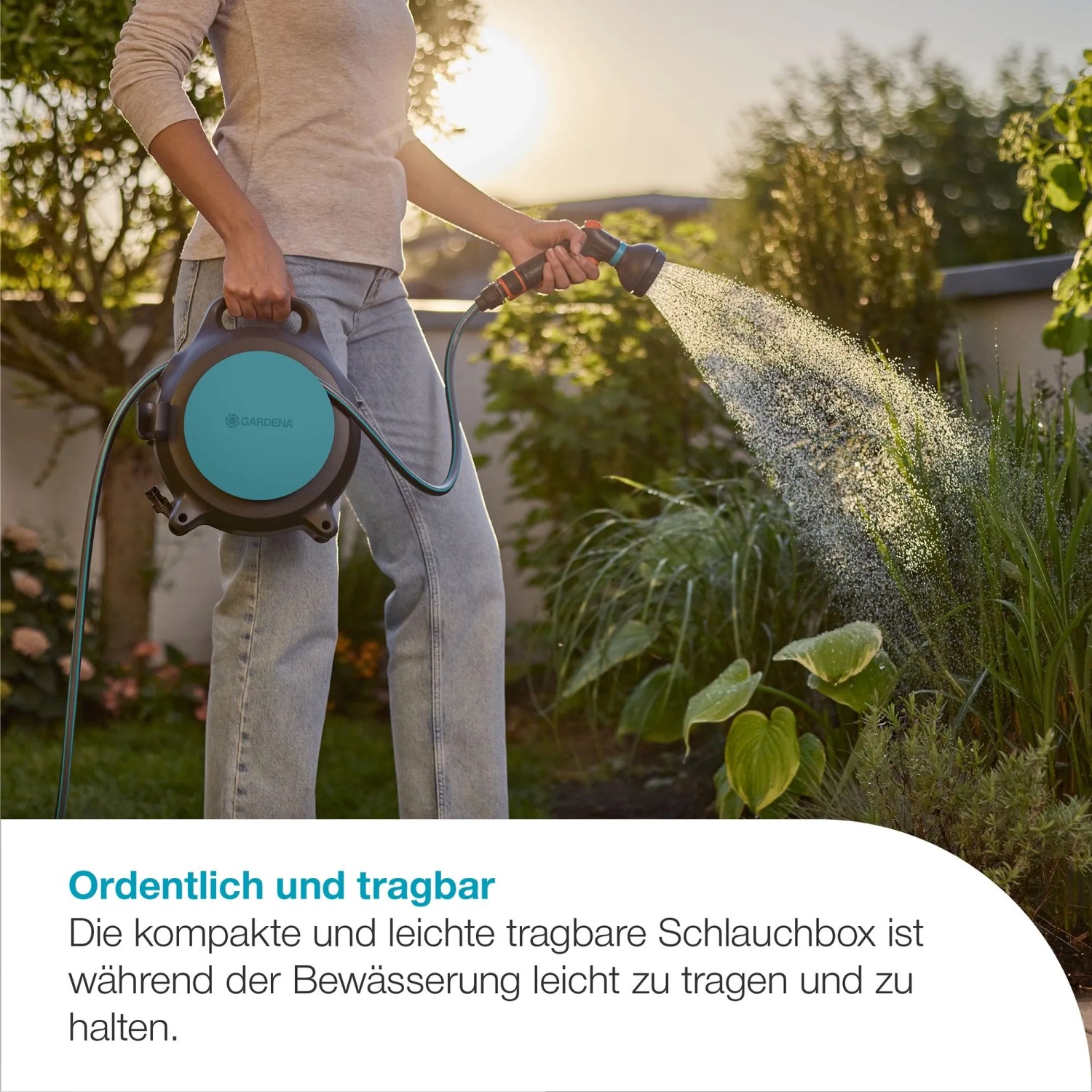 Gardena Schlauchbox Move 10 m in Nutzung: Frau bewässert Garten mit Gartenschlauchwagen.
