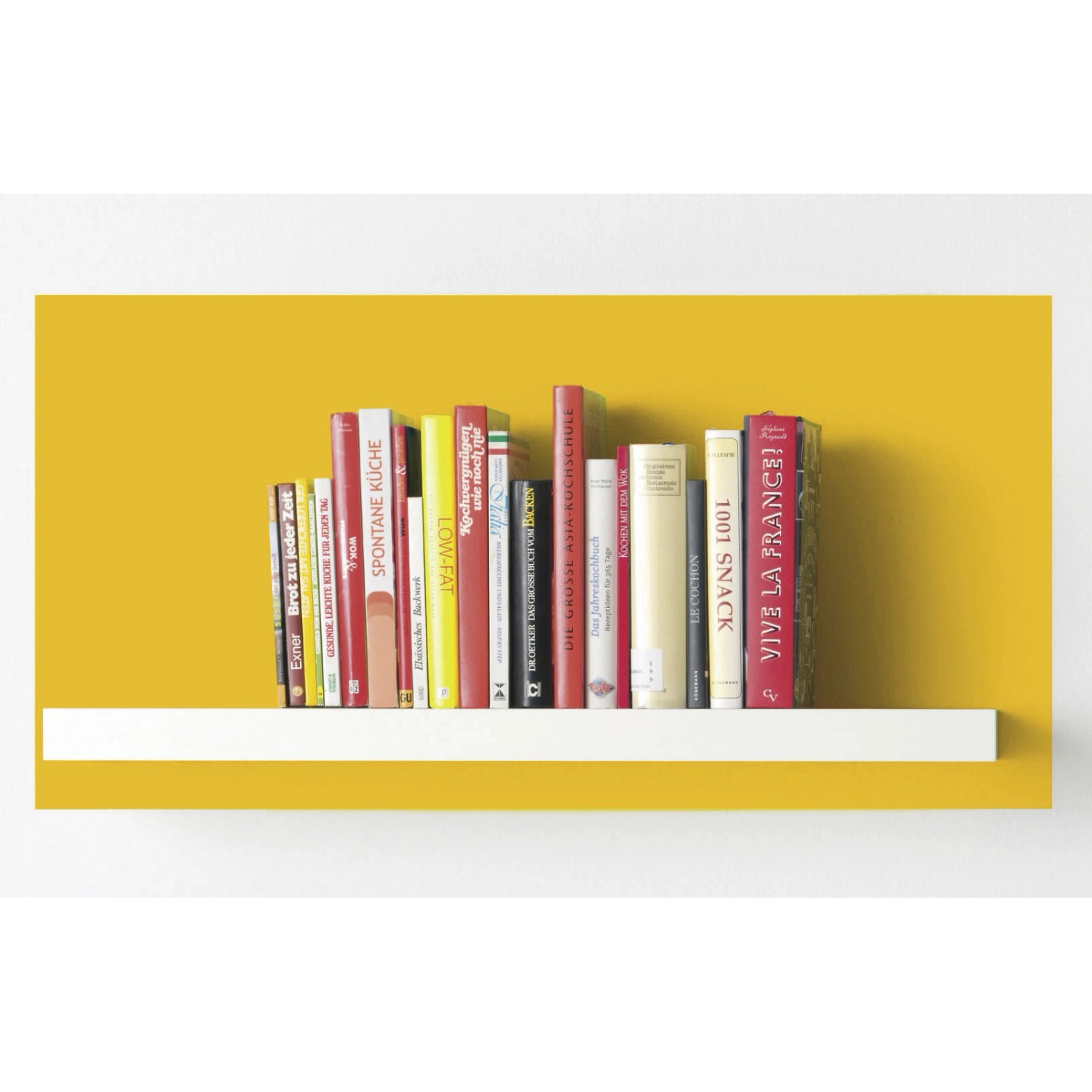 Alpina Color Lucky Yellow: Gelb gestrichene Wand mit Bücherregal und Kochbüchern.