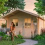 Skan Holz Gartenhaus Como 3 Natur, 300x300 cm, mit Frau im Garten. Holz-Gartenhaus für Geräte und Gartenmöbel.
