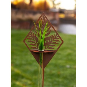 Rostfarbener Gartenstab mit Farnmuster und Reagenzglas zur Dekoration im Garten.