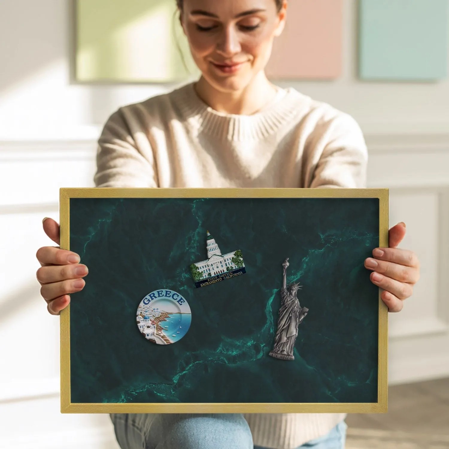 Magnettafel mit Marmor-Print und Goldrahmen, gehalten von einer Person. Pinnwand für Notizen und Magnete.