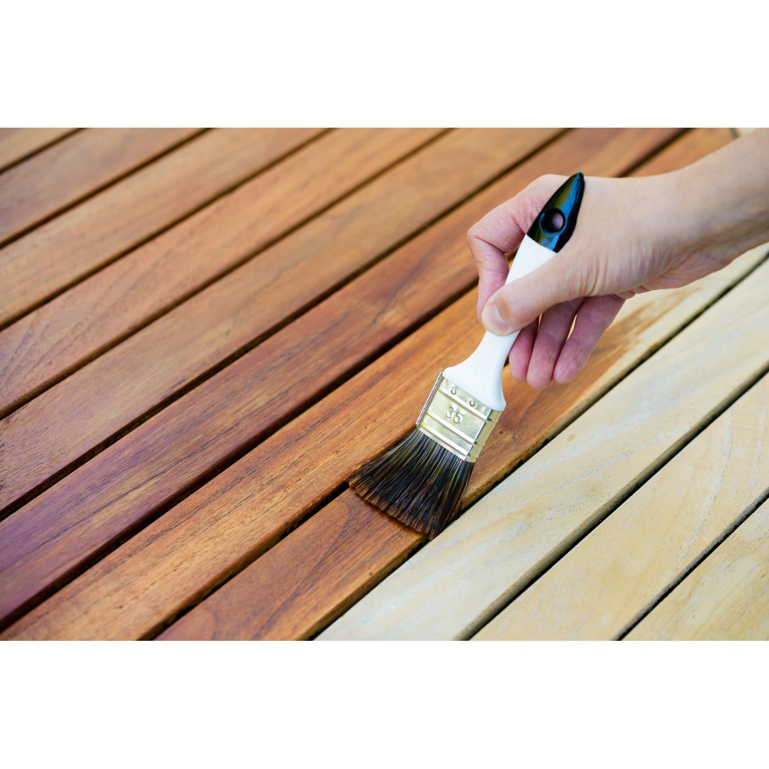 Auftragen von Bondex Wetterschutz-Öl Teak auf Holzterrasse mit Pinsel.
