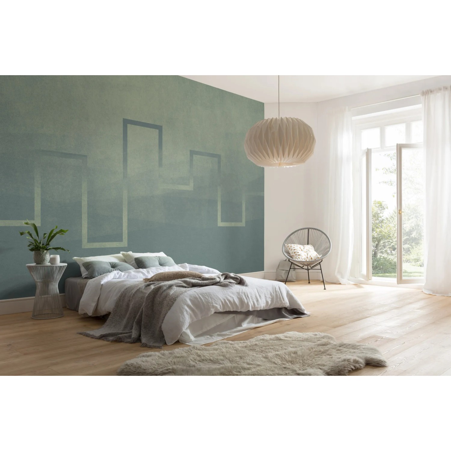 Komar Vlies Fototapete Level im Schlafzimmer mit blau-grünem Farbverlauf und Rahmenmuster.