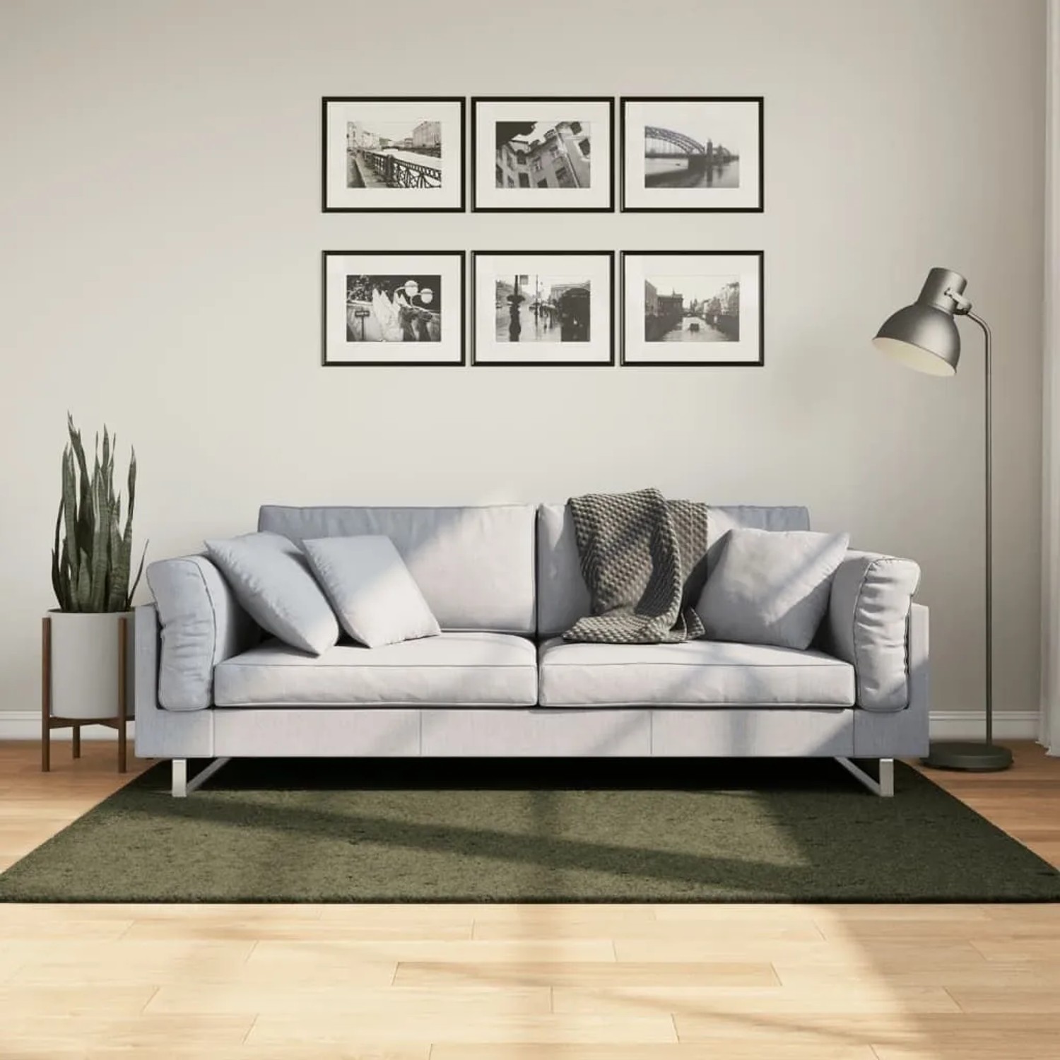 Waldgrüner Kurzflor Teppich 120x170 cm unter hellem Sofa auf Holzfußboden im Wohnzimmer. Weich und waschbar.