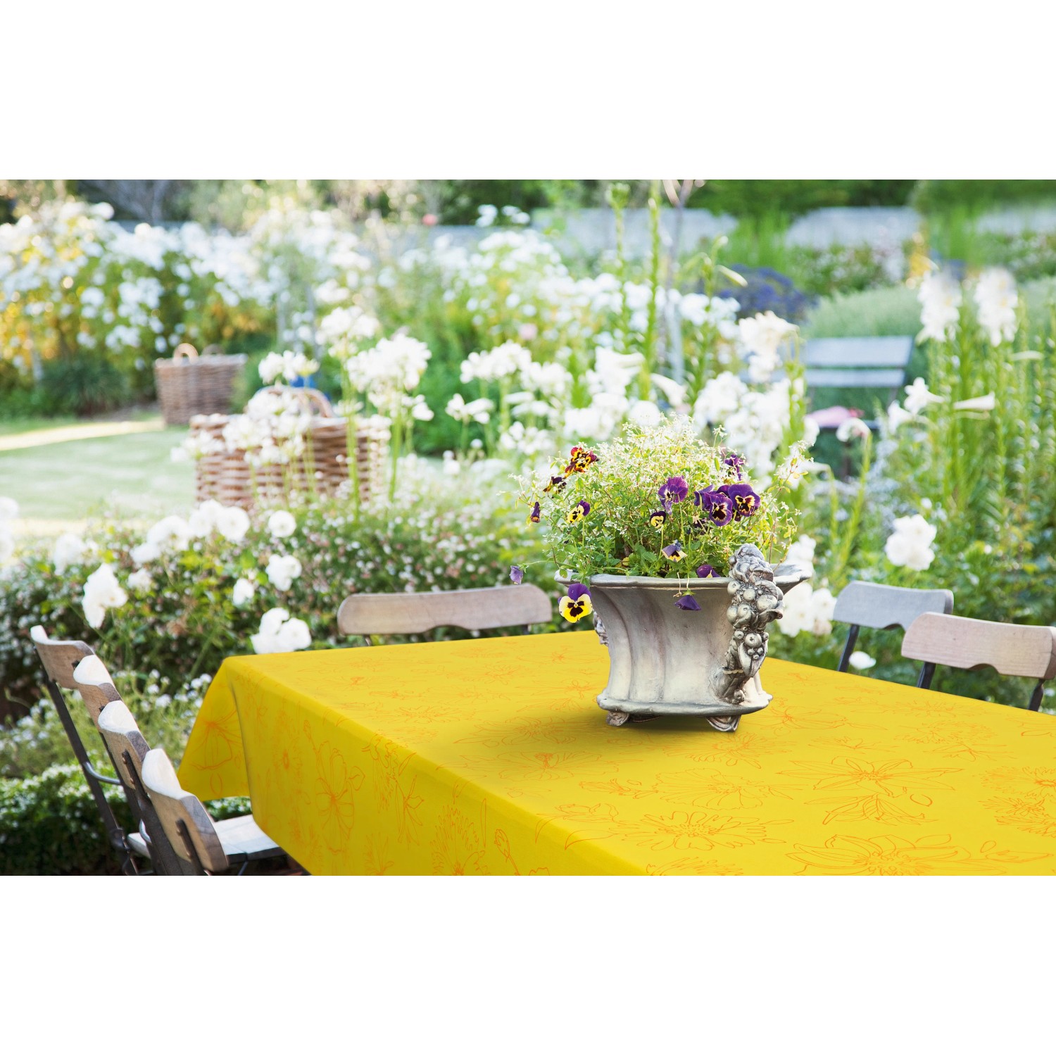 Gelbe, runde d-c-fix Tischdecke Palmas (Ø 150 cm) mit Blumenmuster auf Gartentisch.